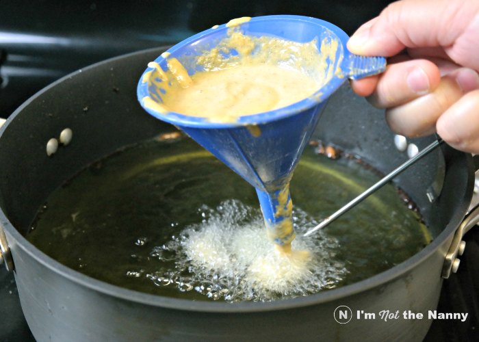 Dropping funnel cake batter into oil